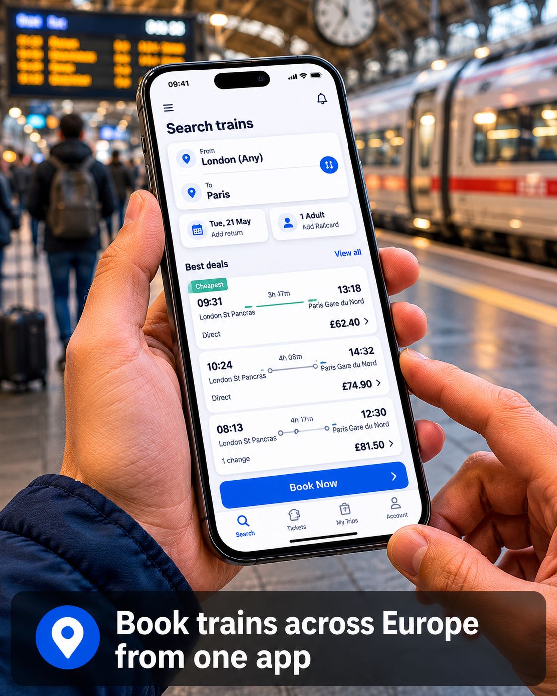 Close-up of hands holding a smartphone with a train booking app open at a train station platform with blurred trains and passengers in the background and the text “Book trains across Europe from one app”.